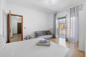 a white bedroom with a bed and a couch at Appartamento Isabella in Verbania