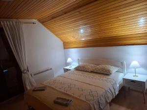 a bedroom with a bed and a wooden ceiling at Holiday house Šadrvan Sarajevo in Hadžići