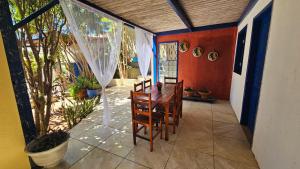 a room with a table and chairs on a patio at Shanti Om Refúgio Pousada e Yoga in Cascavel