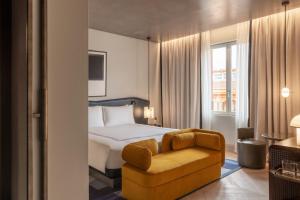 a hotel room with a bed and a chair at Thompson Rome, By Hyatt in Rome