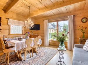 a dining room with a table and chairs in a room at Domek Regionalny Bąkowo Chatka in Witów