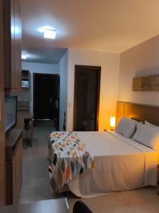 a hotel room with a bed and a television at The Sun Full Condominiun in Brasília