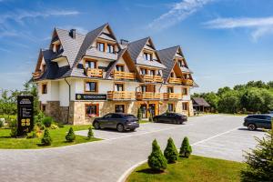 a large building with cars parked in a parking lot at Rezydencja Zakopane in Zakopane +133 photos