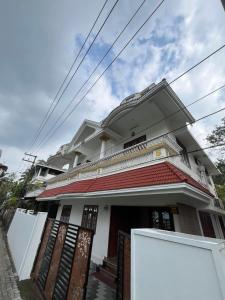 a white house with a red roof at MR Homes in Cochin