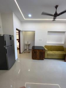 a living room with a couch and a refrigerator at MR Homes in Cochin
