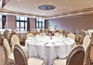 a banquet room with white tables and chairs at Millennium Hotel Paris Charles De Gaulle in Roissy-en-France +23 photos