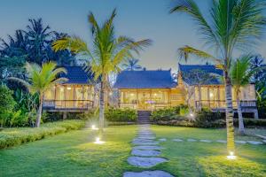 a house with palm trees in front of it at Sacred Padi Ubud Villa in Payangan