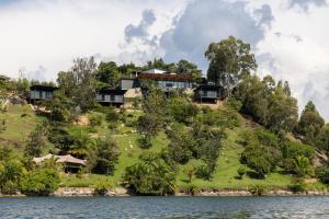 a house on a hill next to the water at Kibuye House in Kibuye