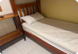 a small bed with a pillow on it in a room at Figueiredo Hosp 1 in Presidente Figueiredo