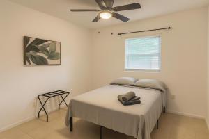 a bedroom with a bed with a ceiling fan at Fauna Beach in Gold Coast Heliport