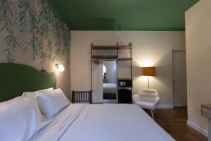 a bedroom with a white bed and a chair at VILLA UGO b & b in Salsomaggiore Terme