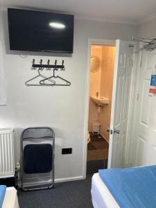 a room with a tv on the wall and a chair at Alma House in Dover