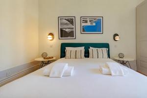 a bedroom with a large white bed with two tables at Mouzinho 226 in Porto