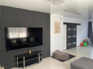 a living room with a large flat screen tv on a wall at Svetes house - Garden & BBQ & Parking in Liepāja