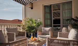 a patio with wicker chairs and tables on a balcony at Only YOU Boutique Hotel Madrid in Madrid +78 photos