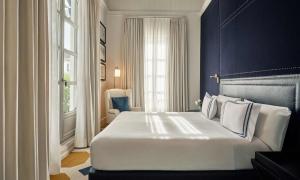 a bedroom with a large white bed with a blue wall at Only YOU Boutique Hotel Madrid in Madrid