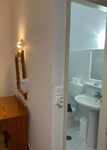 a bathroom with a white toilet and a sink at EFFIE'S STUDIOS in Alinda +28 photos