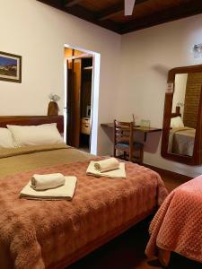 a bedroom with two towels on a bed and a mirror at Hotel & Restaurant Las Brisas in Puerto Esperanza +70 photos