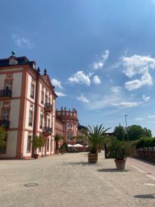 a large building with potted plants in a courtyard at Hotel Am Schlosspark , Wiesbaden in Wiesbaden