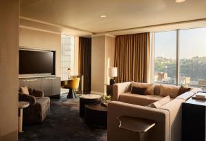 a living room with a couch and a television at Fairmont Pittsburgh in Pittsburgh