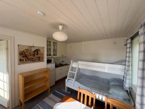 a bedroom with a bunk bed and a kitchen at Övertun in Hamburgsund