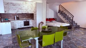 a kitchen and dining room with a table and green chairs at Akrotiria Beach Apart Complex in Nesebar