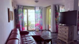a living room with a couch and a flat screen tv at Akrotiria Beach Apart Complex in Nesebar
