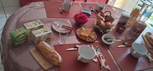 a table with a pink table cloth with food on it at Maison de Caractère Maryann56 in Noyal-Muzillac