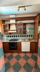 a kitchen with wooden cabinets and a checkered floor at Villa Berlin in Bol