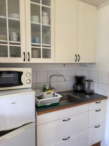a kitchen with white cabinets and a sink at Övertun in Hamburgsund