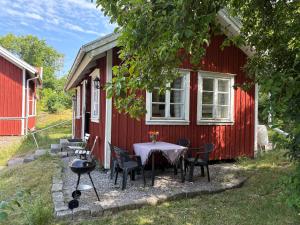 a table and chairs outside of a red house at Övertun in Hamburgsund