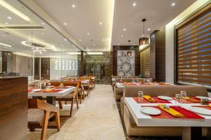 a dining room with tables and chairs in a restaurant at ECONEST HOTEL in Tarapith