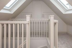 a white crib in a attic with skylights at The Annexe in Cobham