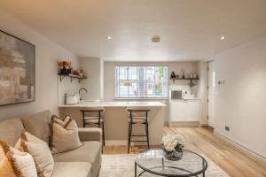 a living room with a couch and a table and a kitchen at The Annexe in Cobham