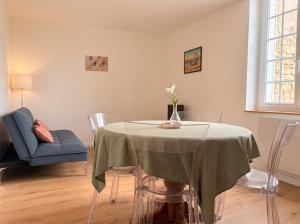 a dining room with a table with a vase of flowers on it at Le Clos des Douves - Jardin privatif - Ingrandes in Ingrandes