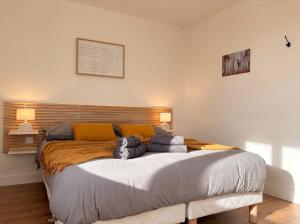 a large bed in a bedroom with two pillows on it at Le Clos des Douves - Jardin privatif - Ingrandes in Ingrandes
