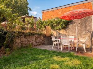 a patio with a table and chairs and an umbrella at Le Clos des Douves - Jardin privatif - Ingrandes in Ingrandes