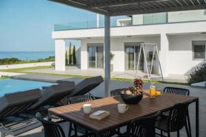 a wooden table and chairs on a patio at Nouvelle Villa in Ierapetra