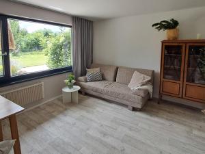 a living room with a couch and a large window at Ferienbungalow Haus Rolf _ Objekt in Papendorf