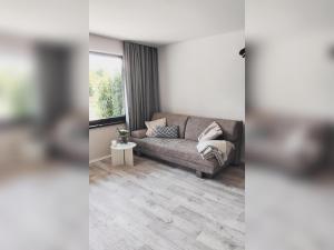 a living room with a couch and a window at Ferienbungalow Haus Rolf _ Objekt in Papendorf +10 photos