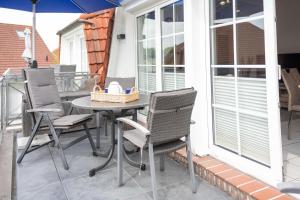 a patio with a table and chairs on a balcony at Nordseeperle in Wangerland