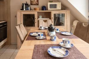 a dining room table with plates and cups on it at Nordseeperle in Wangerland +14 photos