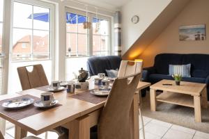 a dining room with a wooden table and chairs at Nordseeperle in Wangerland
