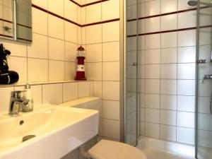a bathroom with a sink and a toilet and a shower at Nordseeperle in Wangerland
