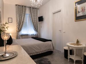 a bedroom with a bed and a table and a window at B&B Jasmine Park Ormea in Ormea +8 photos