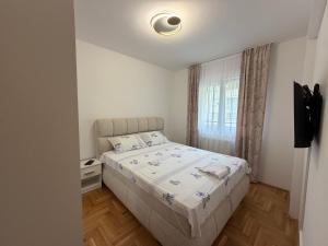 a small bedroom with a bed and a window at Stan na dan Hilandarska 9 in Lukavica