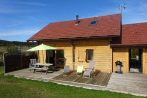 a house with a wooden deck with a table and chairs at Chalet airelles in Saint-Pierre