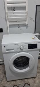 a white washing machine sitting in a room at AiDan BB in Kazarman
