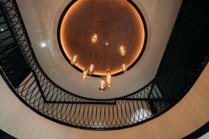 a spiral staircase with a chandelier in a building at Selah Hanoi Hotel in Hanoi
