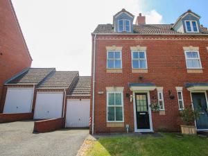a red brick house with two white garage at 18 Hengrave Meadow in Telford